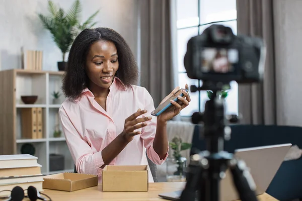 Femme filmant la vidéo tout en ouvrant la boîte avec un nouveau mobile — Photo