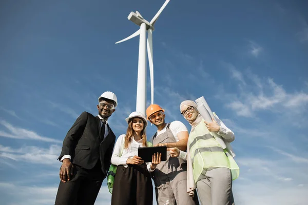 Multiracial coworkers having meeting on farm with windmills — Stock Photo, Image
