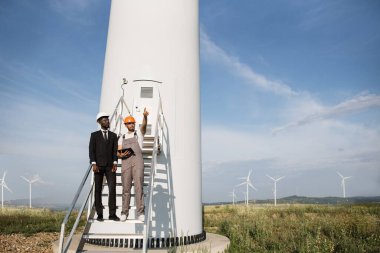 Mühendis ve işadamı, yel değirmenleriyle tava yapmak için tablet kullanıyor.