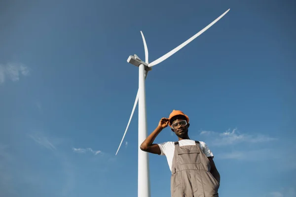 African american technician posing on field with windmills — Zdjęcie stockowe
