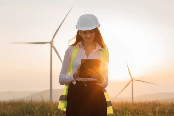 Woman in helmet working with tablet at renewable energy farm — Zdjęcie stockowe
