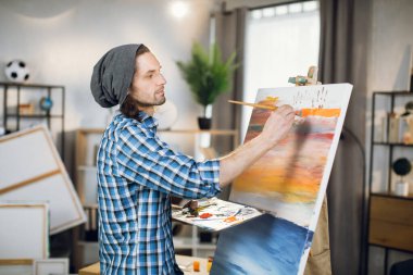 Inspired artist using color palette and brush for painting