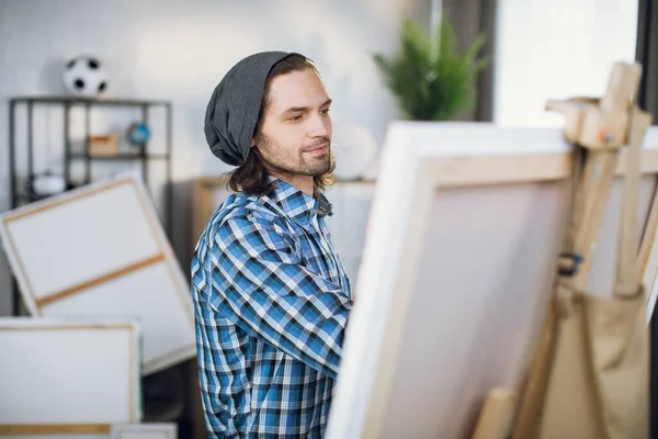 Man drawing with brush on canvas at art studio — Stok fotoğraf