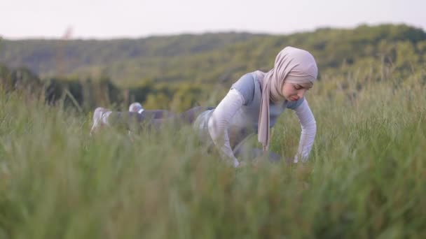 Mulher muçulmana em forma fazendo empurrar para cima ao ar livre. esporte mulher treino — Vídeo de Stock