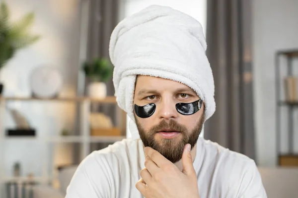 Caucasian man with white towel on his head and black patches under eyes — Stock Photo, Image