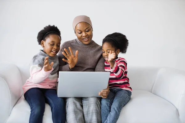 Mãe com filhas usando laptop para chamada de vídeo — Fotografia de Stock