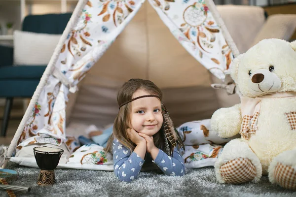 Çadırın içinde uzanmış kameraya bakan sevimli bir çocuk. — Stok fotoğraf