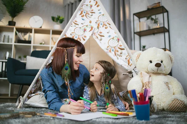 Moeder en dochter tekening in album in tipi tent — Stockfoto