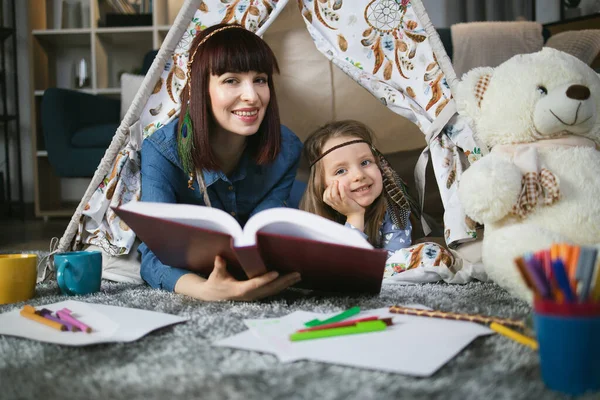 Çocuk ve kadın çadırda kitap okuyorlar. — Stok fotoğraf