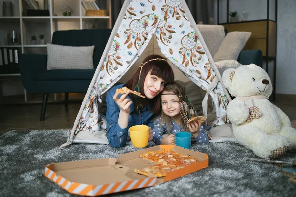 Ibu dan anak mengadakan pesta rumah dengan pizza dan teh — Stok Foto