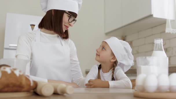 Jovem bela mãe passar uma manhã feliz cozinhando biscoitos com adorável pequena filha — Vídeo de Stock