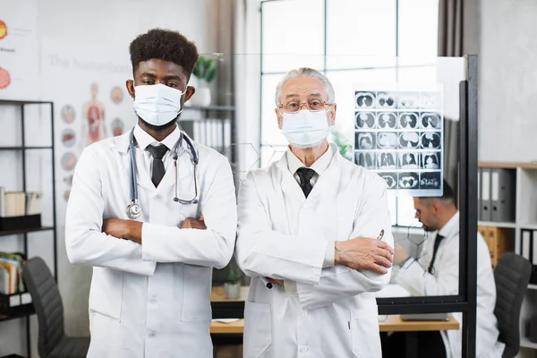Два медичні працівники в масках для обличчя позують в приміщенні — стокове фото