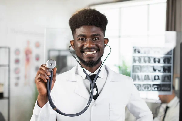 Afrikai orvos kezében sztetoszkóppal és a kamerába néz — Stock Fotó