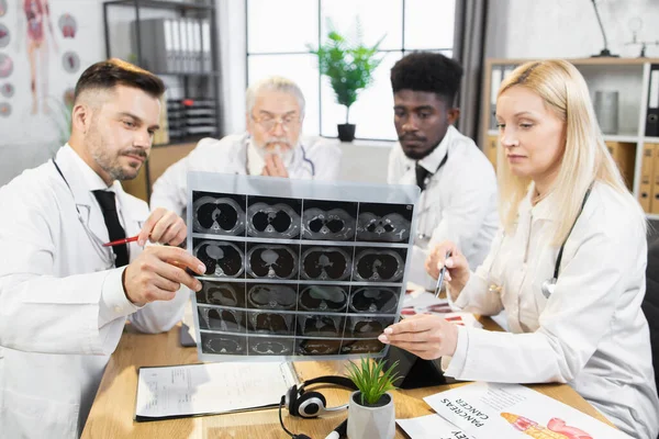 Quatro médicos multi étnicos examinando os resultados da tomografia — Fotografia de Stock