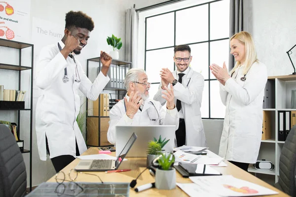 Multicultural doctors smiling and clapping during conference — Stock Photo, Image