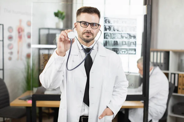 Dottore in camice da laboratorio e occhiali in posa con stetoscopio — Foto Stock