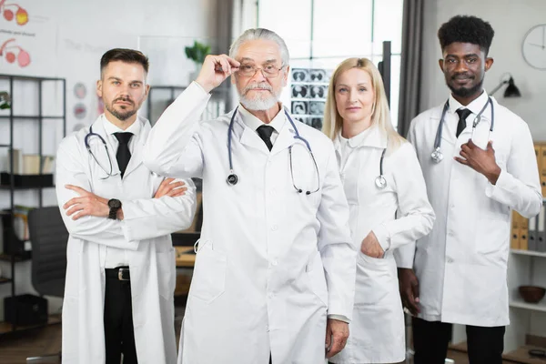 Quattro operatori medici multirazziali in posa al chiuso — Foto Stock