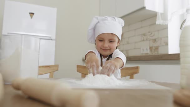 Dzieciak posypać ciasto mąką, uśmiecha się szczęśliwy — Wideo stockowe