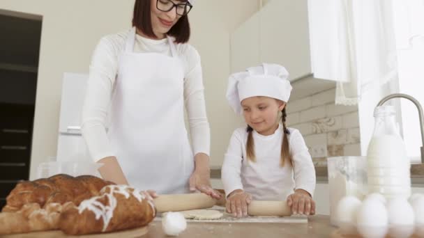 Usmívající se mladá maminka nebo chůva výuka malá dcera dělá pekařství doma kuchyně — Stock video