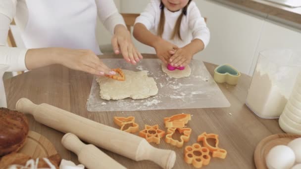 Маленька мила дівчинка та її мати готують печиво використовуючи печиво . — стокове відео