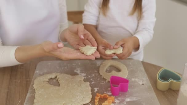 Close-up van familie moeder en dochter houden in handen rauwe hartvormige en kerstboom koekjes — Stockvideo