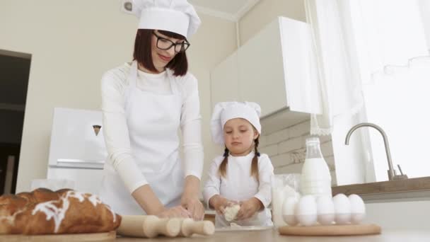 Valkoihoinen äiti ja tytär leipovat yhdessä taikinaa ja käyttävät ainesosia.. — kuvapankkivideo