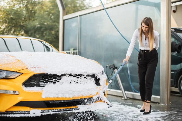 Atrakcyjny biały kobieta nosić w biznesie wygląd myć jego żółty samochód z pianką — Zdjęcie stockowe
