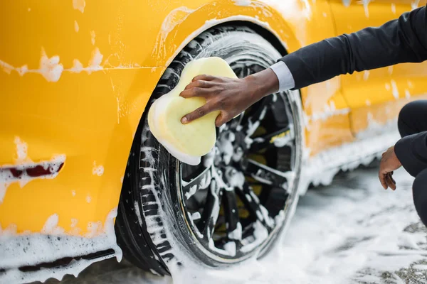 在室外自动洗车服务中清洗豪华黄色汽车的现代轮缘. — 图库照片