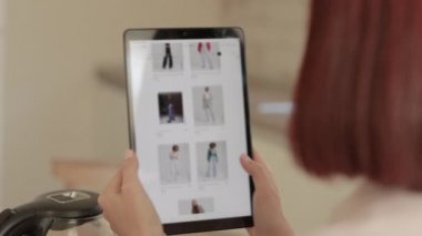 Ekranda web mağazası olan kadın elleri tableti tutuyor.