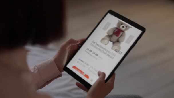 Online shop op tablet display in jonge blanke vrouw handen op zoek naar een speeltje voor haar baby te kopen. — Stockvideo