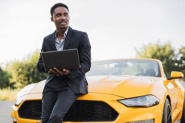 Laptopla çalışan yakışıklı Afro-Amerikan iş adamı.