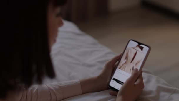 Close up of woman with online shop web page on mobile phone screen on her hand. — Stock video