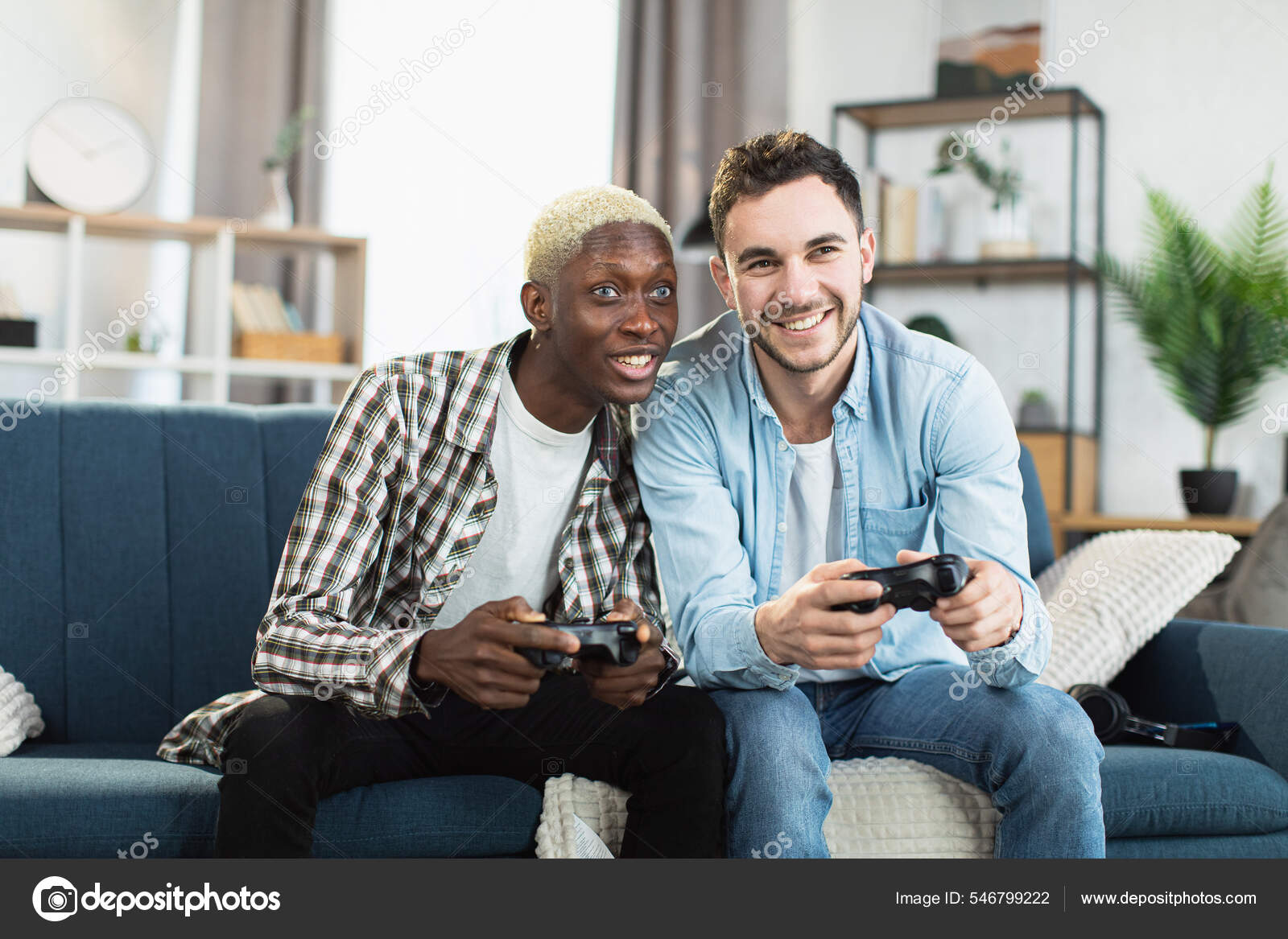 Multi ethnic same sex couple playing video games at home Stock Photo by ©sofiiashunkina@gmail 546799222