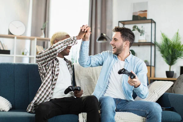 Neşeli eşcinseller video oyunlarında zafer sırasında beşlik çakıyor. — Stok fotoğraf