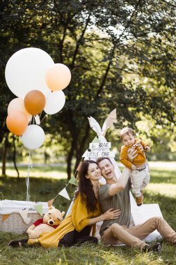 Mutlu ebeveynler oğluyla dışarıda oynuyorlar.