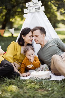 Ebeveynler dışarıda doğum gününü pastayla kutluyorlar.