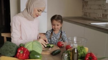 Güzel Müslüman anne ve kızı mutfakta lezzetli yemekler hazırlıyorlar..