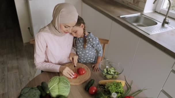 Musulmán joven mamá y lindo pequeño preescolar hija divertirse preparando comida en cocina — Vídeos de Stock