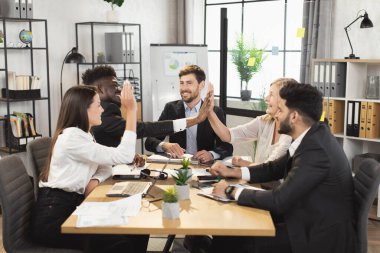 Diverse business people giving high five on meeting clipart