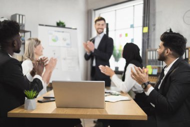 Çok ırklı iş adamları toplantı sırasında el çırpıyorlar.