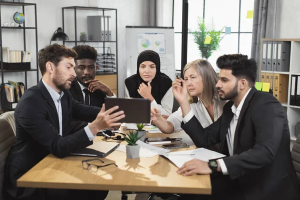 Multietničtí partneři používající tablet při schůzce v kanceláři — Stock fotografie