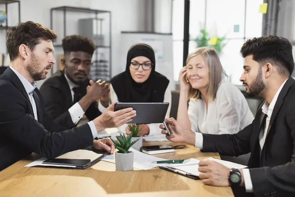 Grupo multi étnico de empresários usando tablet no escritório — Fotografia de Stock