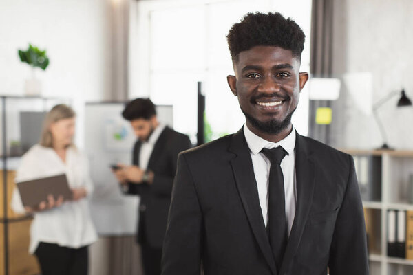 Successful african businessman smiling on camera at office