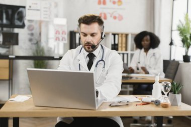 Hasta ile çevrimiçi randevusu olan kulaklıklı bir doktor.