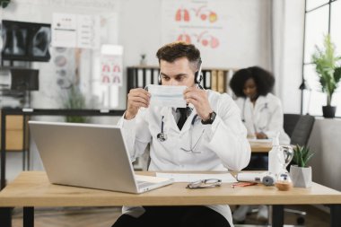 Doktor internette hastaya yüz maskesi takmayı anlatıyor.