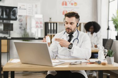Kulaklık takan doktor hastayla çevrimiçi istişare yapıyor.
