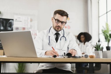Video çağrısı sırasında hastaya reçete yazan doktor