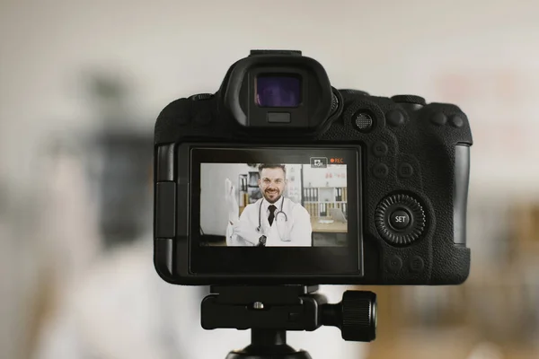 Вид на экран камеры с врачом, надевающим резиновые перчатки — стоковое фото