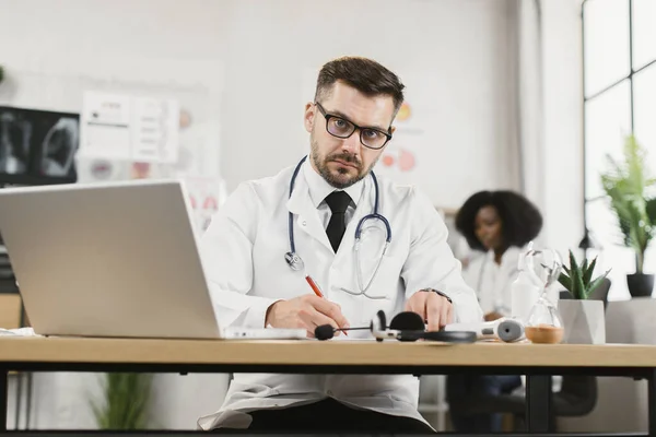 Médecin écrivant prescription au patient pendant l'appel vidéo — Photo