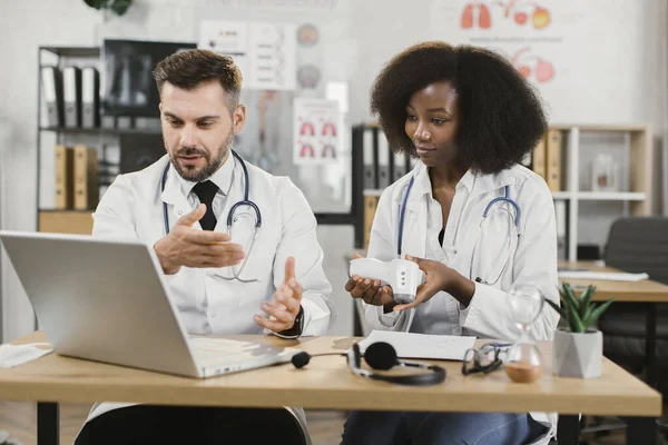 Deux travailleurs médicaux utilisant un ordinateur portable moderne pour le séminaire en ligne — Photo